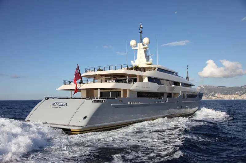 Azteca's transom underway off Monaco, the painted AZTECA DOUGLAS nameplate and Red Ensign identifying her port of registry.