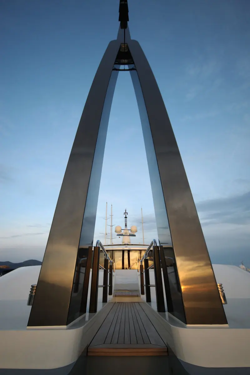 An architectural close-up of Azteca's stern arch and open-frame superstructure detailing at dusk.