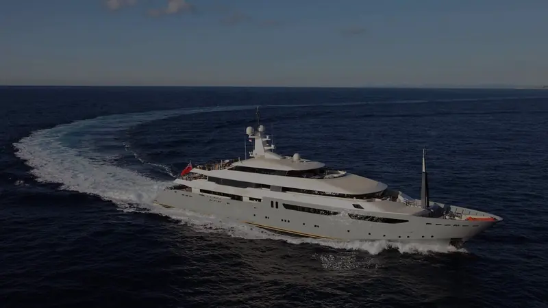 Azteca underway broadside past a different stretch of coastline, showing her full profile at speed.