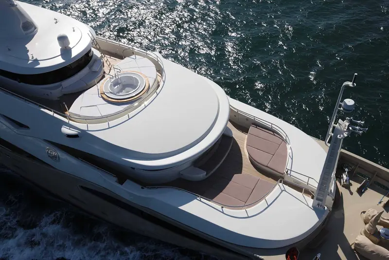 An overhead view of the bow lounge area with its built-in spa pool, shot low and close to the deck.