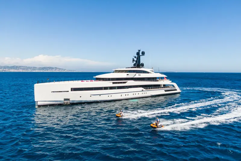 Rio underway with two jet skis running alongside, launched from the yacht's own tender garage.