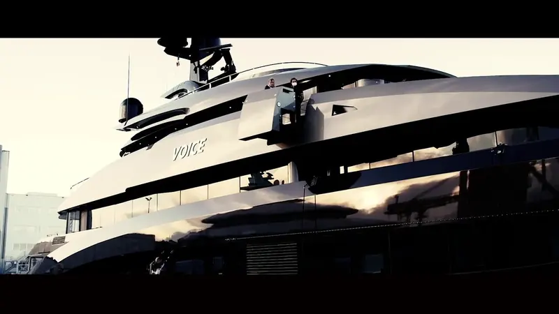 A backlit stern-quarter view at dusk, the yacht's silhouette picked out against the fading light.