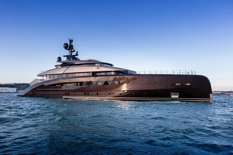 Voice running on open water at dusk, no coastline visible, the hull throwing a long wake astern.