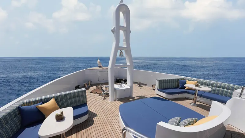 The aft sundeck lounge, with the ship's bell mounted on the mast structure ahead of the seating.