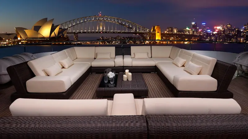 Moored against the Sydney skyline at night, with the Opera House and Harbour Bridge both lit, showing the EP150 in active charter use.