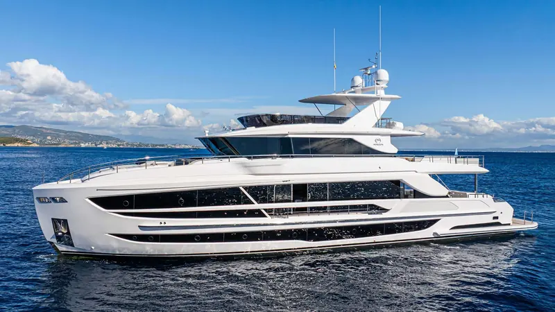 Cruising in open water, showing the flybridge hardtop and mast electronics array from the beam.