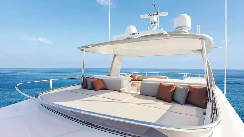 The foredeck seating area under a fixed hardtop, forward of the pilothouse windows.