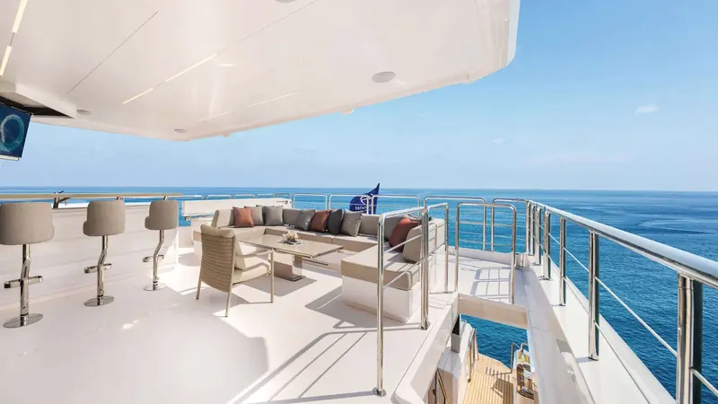 A side deck bar with stools set against the rail, one of two informal entertaining spots on the upper deck.