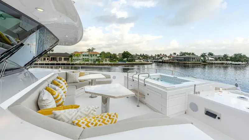 The aft deck spa pool moored on a Florida canal, with waterfront homes visible across the water.