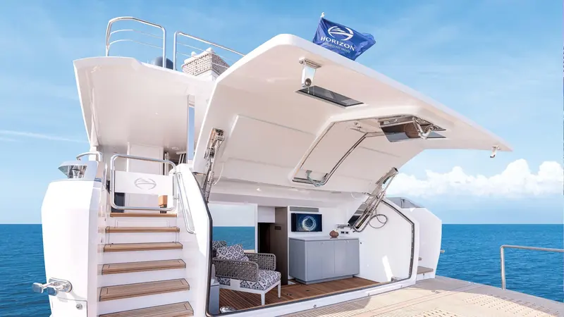 The stern garage stands open above the swim platform, with the stairway up to the aft deck alongside.