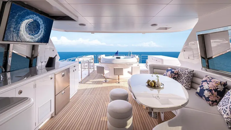 Dining on the sheltered aft deck, with a television set into the side of the deckhouse.