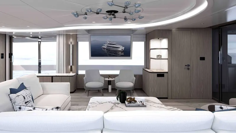 The main-deck salon runs open to a bar with four stools aft, lit by a custom chandelier over the marble coffee table.