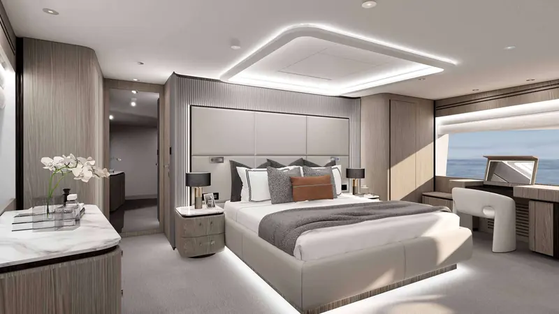 The master stateroom sets a full-beam berth against a padded leather headboard, with a vanity and window seat to starboard looking out over the water.