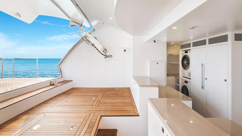 The transom garage opens onto the swim platform, with the crew laundry and stacked washer-dryer just inside, the practical machinery a brochure render never shows.