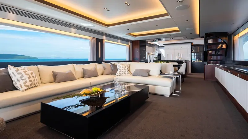 The main saloon runs full-beam, with low-set windows keeping the sea and the nearby islands in view from the sofa.
