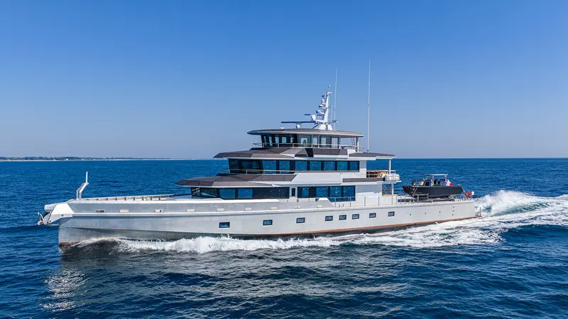 Canoa underway, side profile showing the glazing that runs the length of her accommodation decks.