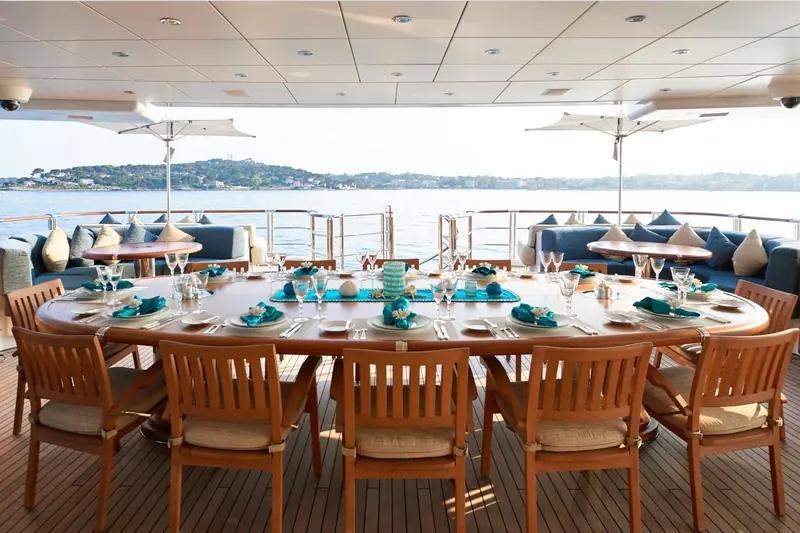 Aft deck dining laid for lunch under a retractable awning, overlooking the anchorage.