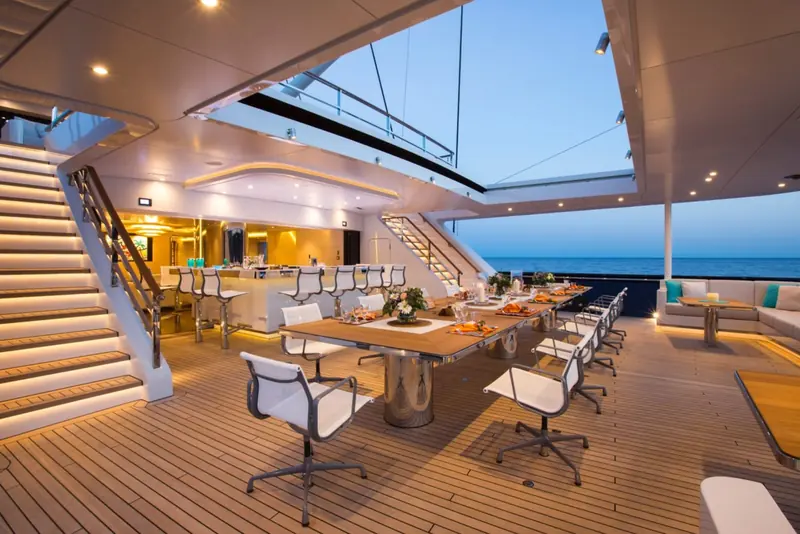 The aft deck dining table laid under the boom, set for a lunch stop at anchor.