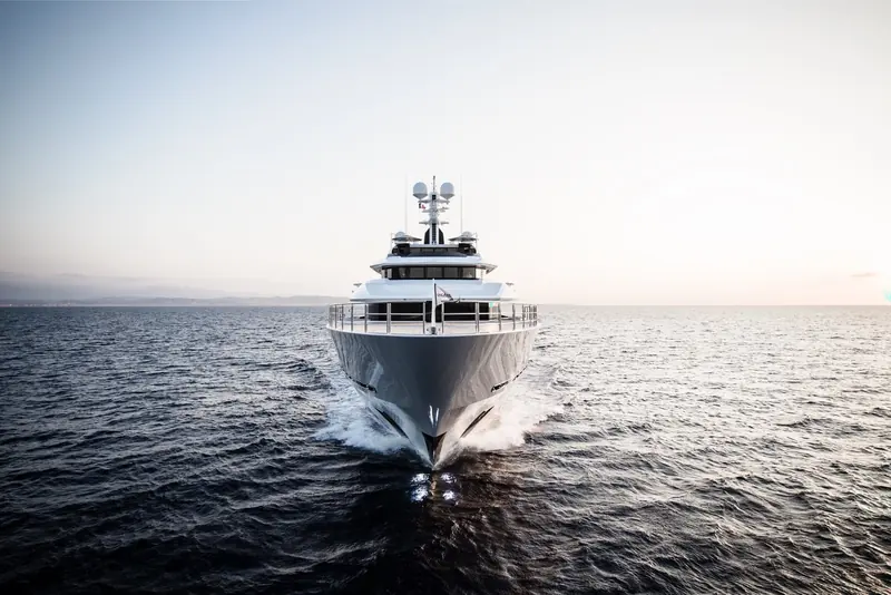 DreAMBoat running bow-on at dusk, twin bow thrusters cutting a clean wake either side of the stem.