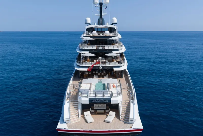 Aerial view aft, showing all four open-deck levels stacked above the transom-mounted pool.
