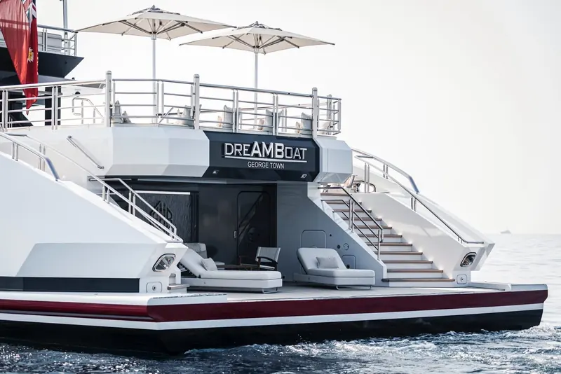 The transom nameplate and swim platform, flanked by twin staircases up to the beach club sun deck.