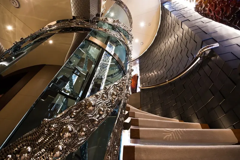 A jewelled glass staircase spirals around the yacht's atrium lift.