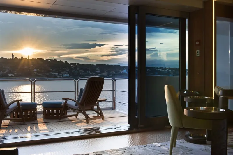 Sunset over a Mediterranean anchorage, seen from a private aft terrace off the main lounge.