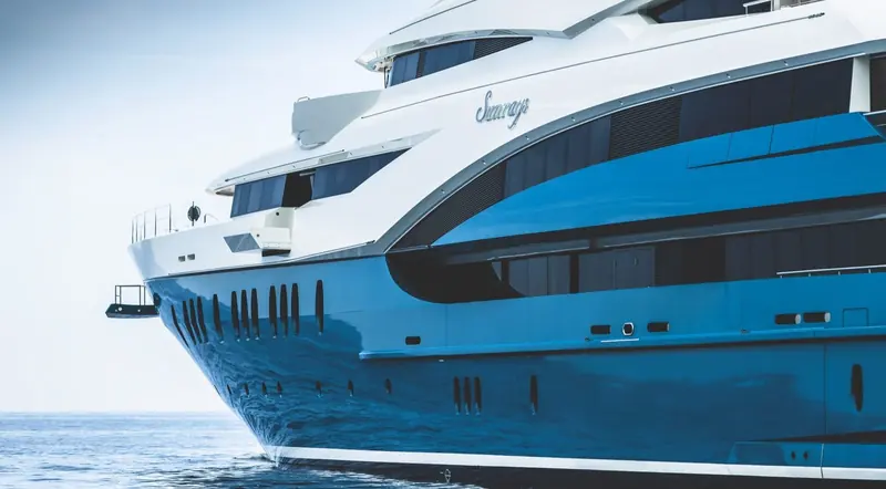The bow close alongside, showing the teal hull graphics and the Sunrays lettering at the stem.