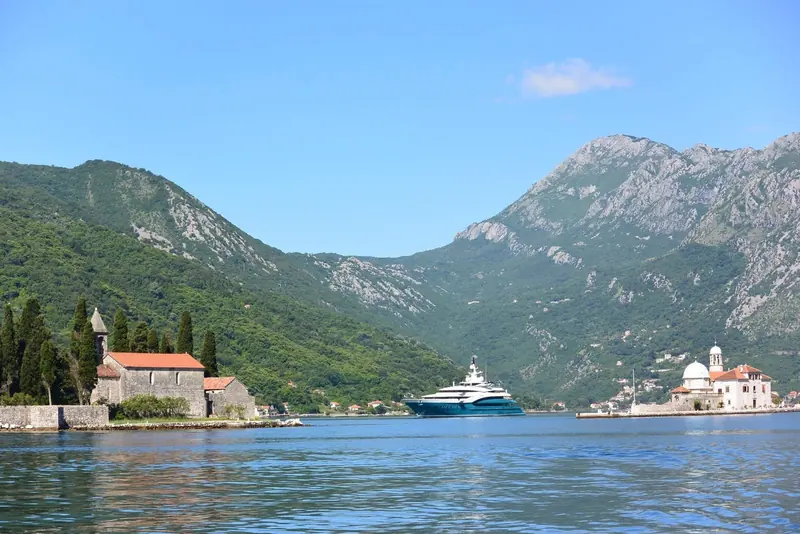 Anchored off Perast in the Bay of Kotor, the islet churches of Our Lady of the Rocks and St George behind her.