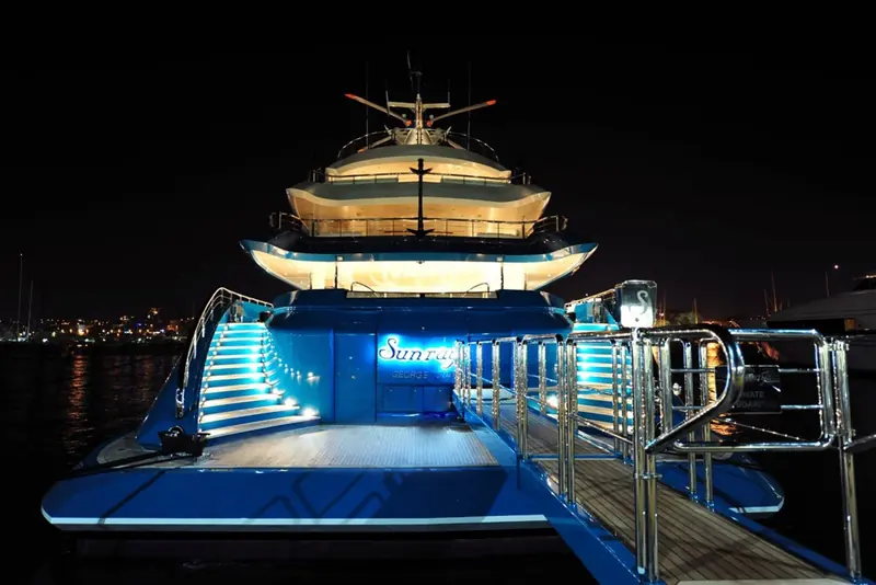Underway at night, the hull lit from the waterline and the name illuminated on the transom.