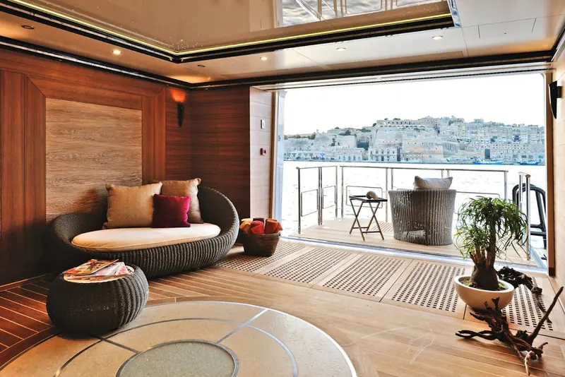 A guest lounge opens onto a private balcony overlooking a fortified harbour town in Malta.