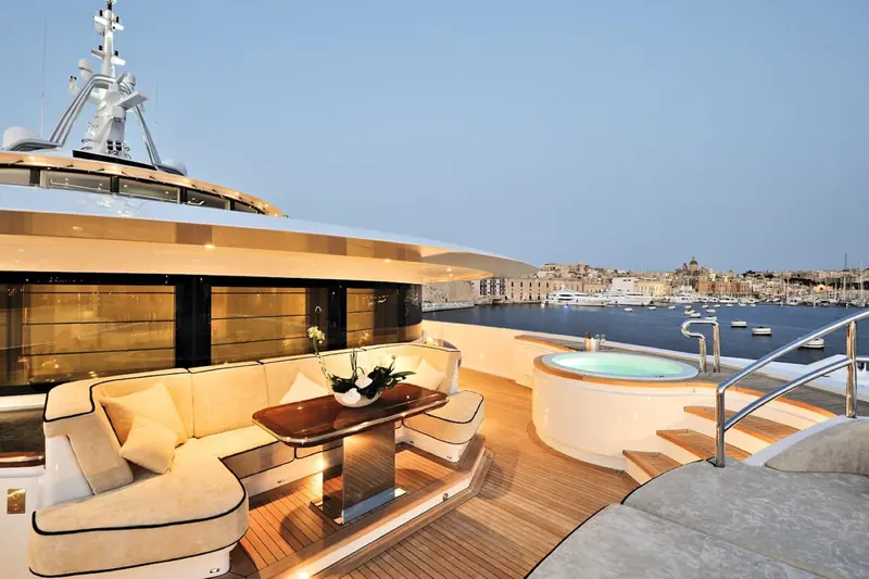 Aft deck seating looking out over a harbour town's rooftops and church domes.