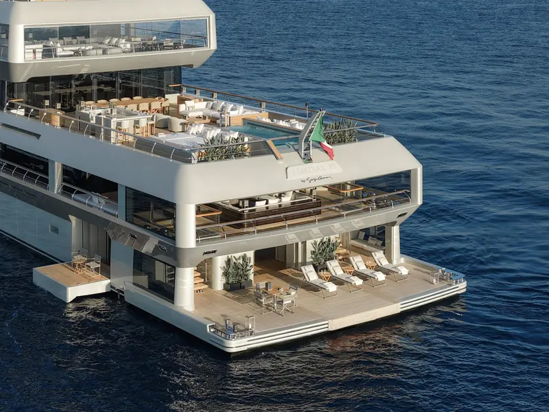 The aft beach club deck, with the yacht's name and the Giorgio Armani signature cast into the transom above the fold-down swim platform and its own sun pads.