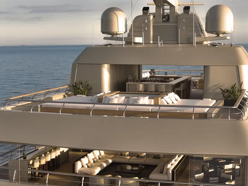 A sunken jacuzzi and full bar sit forward on the sundeck, monogrammed cushions and a container ship on the horizon giving away this is the real boat, not a rendering.