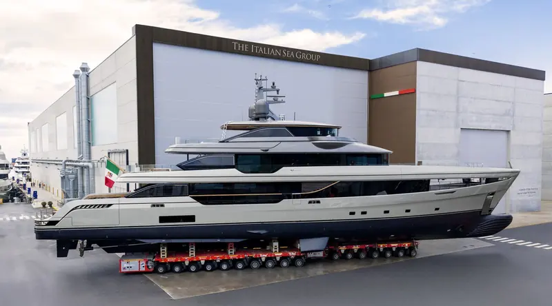 The finished hull leaves The Italian Sea Group's Marina di Carrara shed on a self-propelled modular transporter for the short road-and-slipway move to the water.
