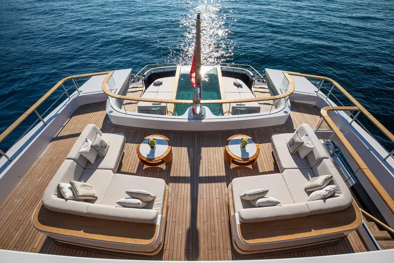 The foredeck sun pad, four loungers set either side of the anchor windlass housing under a stainless bow rail.