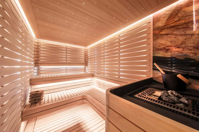 An onboard sauna finished in slatted cedar, with its own coal-effect stove rather than the usual electric heater.