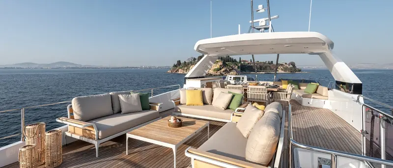 The flybridge seating area under the hardtop, with a full outdoor galley and dining table for entertaining at anchor.