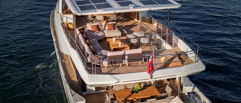 The flybridge seating and alfresco dining area, with the solar panels forming a hard shade canopy overhead.
