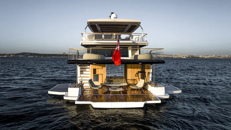 Stern-on under way, the folding side terraces retracted and an elliptical machine set up on the covered aft deck for use at anchor.