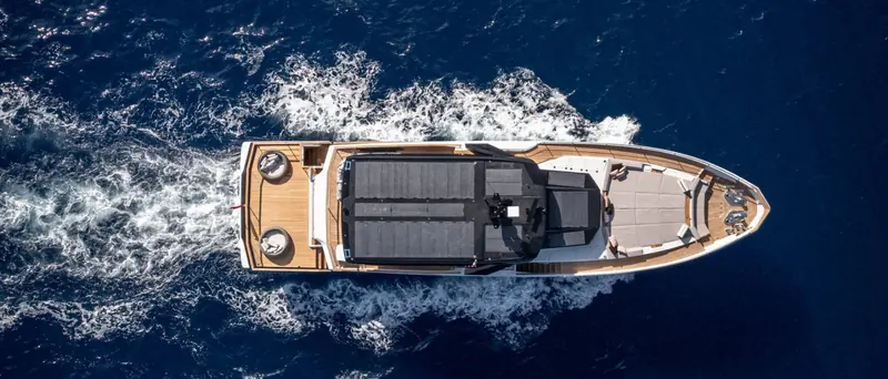 Overhead astern, the wake showing the hull's displacement-style turn of bilge rather than a planing deep-V.