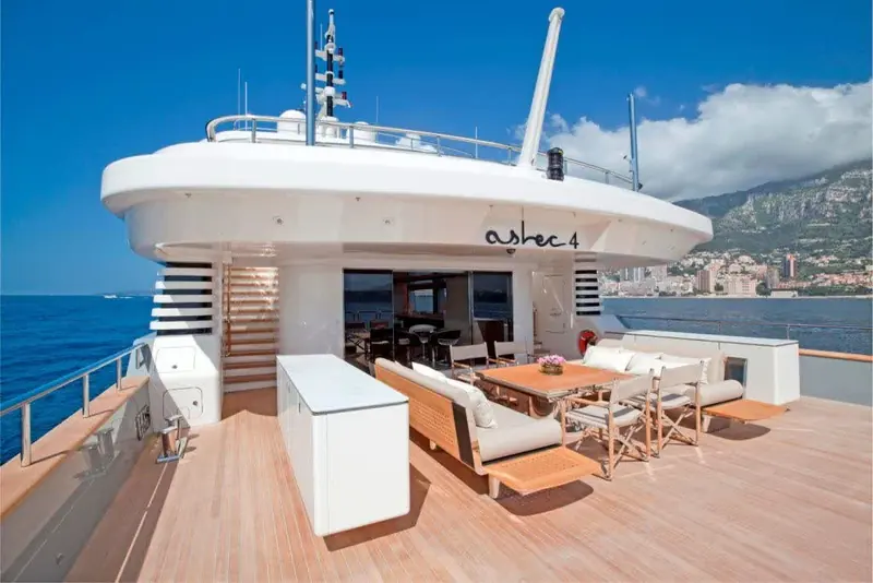 The aft deck is fitted as an open dining and lounge space, with the boat's name hand-painted across the transom rather than applied as vinyl.