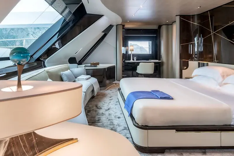 A guest cabin built into the angled forward hull glazing, with a separate desk nook set behind sliding black-lacquer doors.