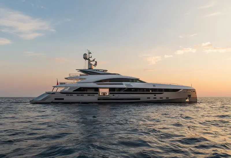 EIV underway at sunset, her superstructure broken into distinct glazed and solid volumes rather than one continuous hull side.