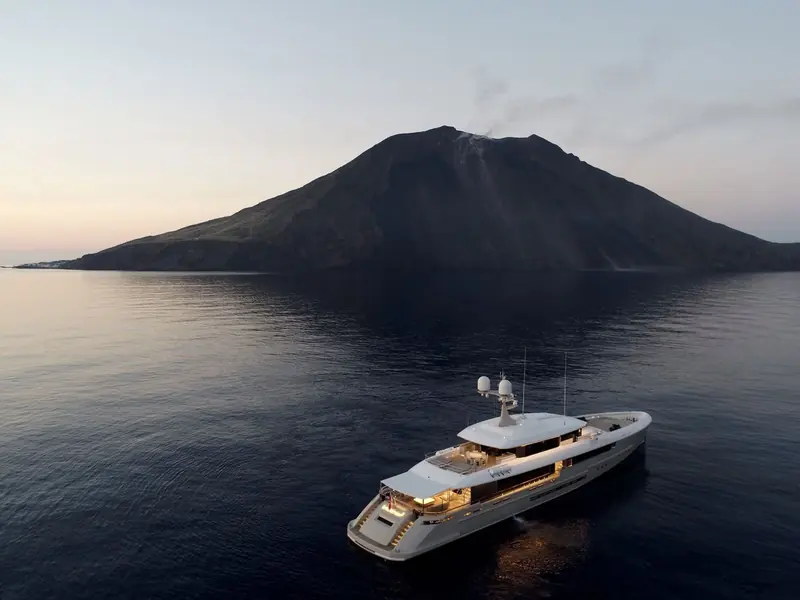 Endeavour II anchored off Stromboli in the Aeolian Islands, the active volcano's cone behind her giving a sense of the remote cruising grounds an explorer-style hull like this is built for.