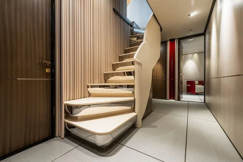 An internal spiral staircase finished in pale timber, its open treads and lack of a central column giving the stairwell more natural light than a boxed companionway.