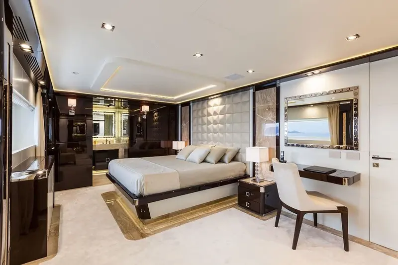 A guest suite finished in dark high-gloss wood, the wall mirror doubling as a second window onto the coastline.