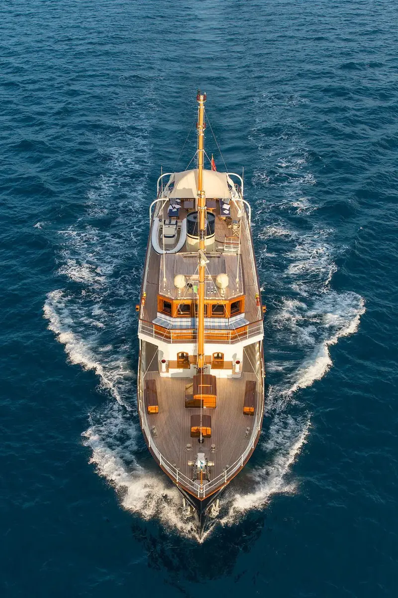 Seen dead astern at speed, teak decks laid fore to aft and the mast standing clear of the awning amidships.
