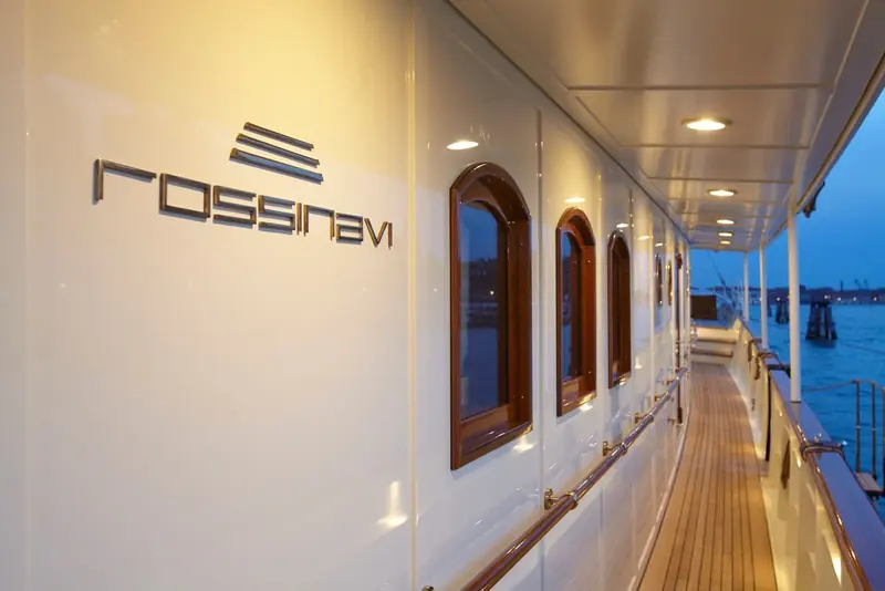 A side passageway showing the builder's name plate, the arched window shapes carried over from the yacht's original design language.