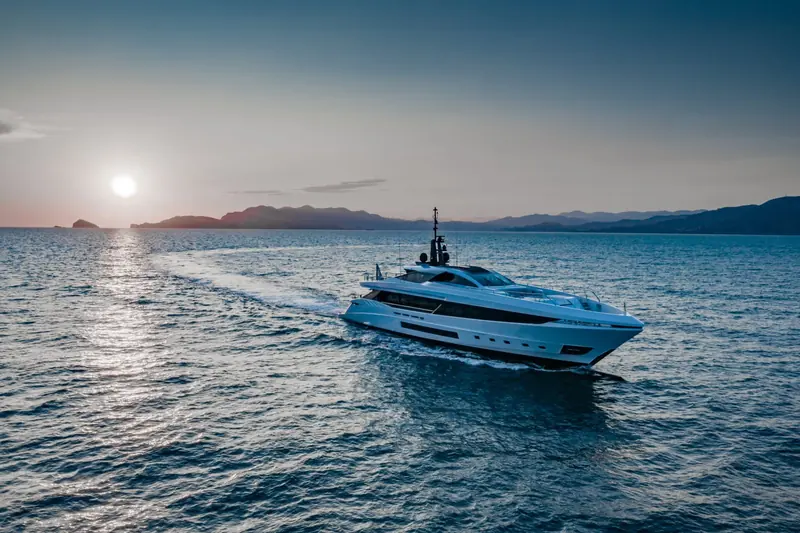 The GranSport 45 at sunset, her white hull lit warm and low against calm water.